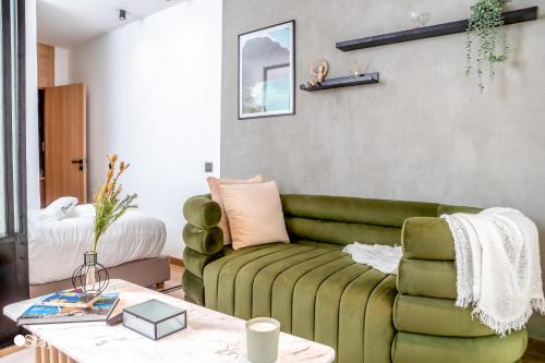 a living room with a green couch and a table at Stayhere Casablanca - Gauthier 1 - Modern Residence in Casablanca