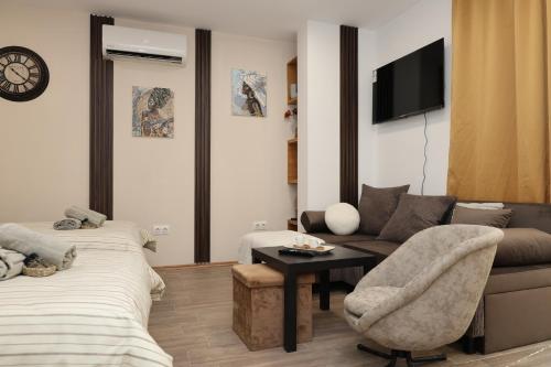 a living room with a couch and a tv at Good Mood Apartments & Parking 2 in Plovdiv