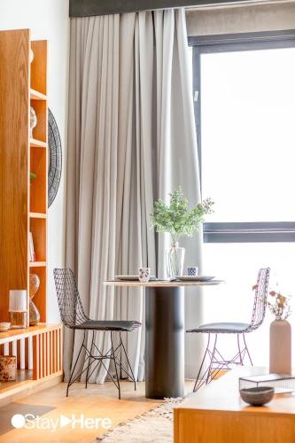 a living room with a table and chairs and a window at Stayhere Casablanca - Gauthier 1 - Modern Residence in Casablanca