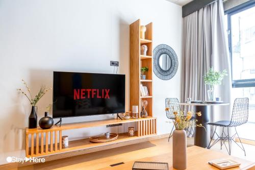a living room with a television on a wooden entertainment center at Stayhere Casablanca - Gauthier 1 - Modern Residence in Casablanca