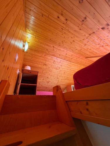 a small room with a bed in a wooden wall at bouda Pod Sněžkou in Pec pod Sněžkou