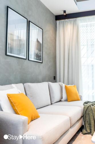 a white couch with orange pillows in a living room at Stayhere Casablanca - Gauthier 1 - Modern Residence in Casablanca