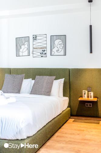 a bedroom with a white bed with pictures on the wall at Stayhere Casablanca - Gauthier 1 - Modern Residence in Casablanca