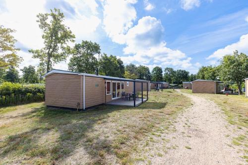 a small cabin in the middle of a field at Welcome in - Chalet Bosdier, Camping de Duinhoeve Burgh-Haamstede in Burgh Haamstede