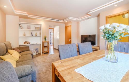 a living room with a table with a vase of flowers at 3 Bedroom Stunning Home In Miami Platja in Miami Platja