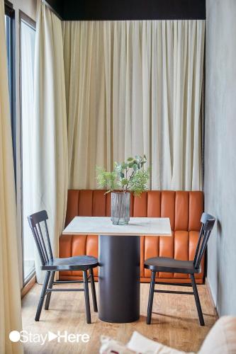 a table and chairs with a vase of flowers on it at Stayhere Casablanca - Gauthier 1 - Modern Residence in Casablanca