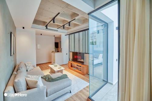 a living room with a couch and a glass wall at Stayhere Casablanca - Gauthier 1 - Modern Residence in Casablanca