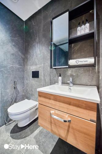a bathroom with a toilet and a sink and a mirror at Stayhere Casablanca - Gauthier 1 - Modern Residence in Casablanca