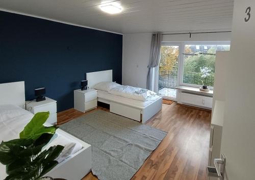 a bedroom with a white bed and a blue wall at Werkswohnnung Heide Süderholm in Heide