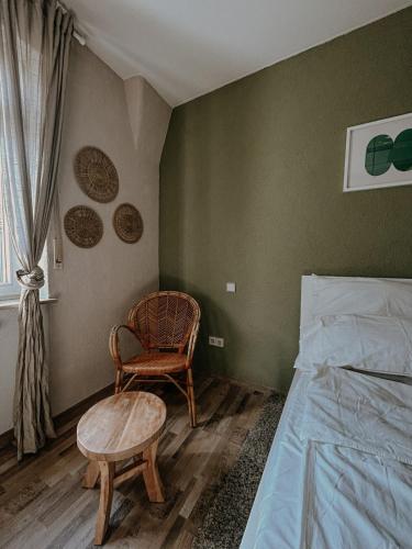 a bedroom with a bed and a chair and a table at Stylish apartment mit Bachblick in Vallendar