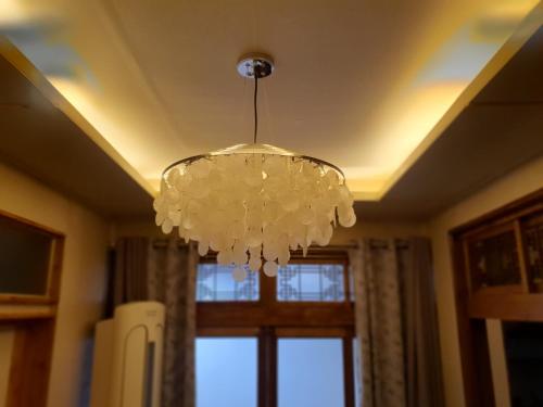 a chandelier hanging from a ceiling with a window at Hanok Stay Ohneul in Gyeongju