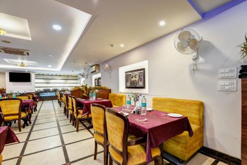 a dining room with tables and chairs in a restaurant at Airport La Sapphire Hotel & Restaurant in New Delhi