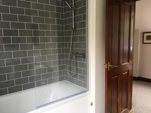 a bathroom with a shower with gray tiles at Pheasant in Welney