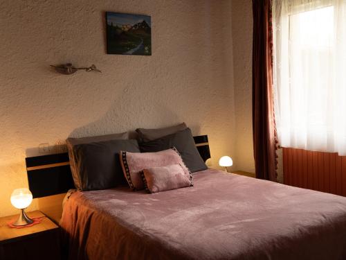 una camera da letto con un letto con due lampade sopra di Gîte dans hameau a Ugine
