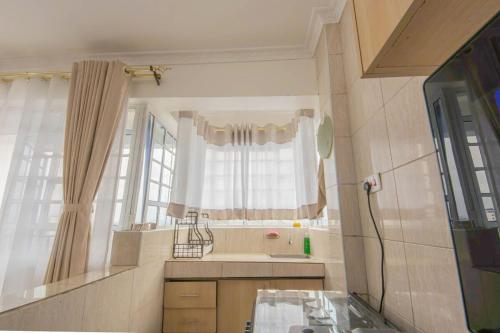 une cuisine avec une fenêtre et une table en verre dans l'établissement Serene Spaces Garden Estate, à Gatunga