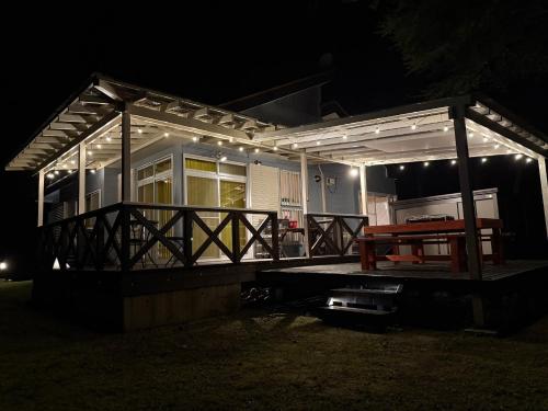 a house with a deck at night with a picnic table at コテージ33 in Nasu