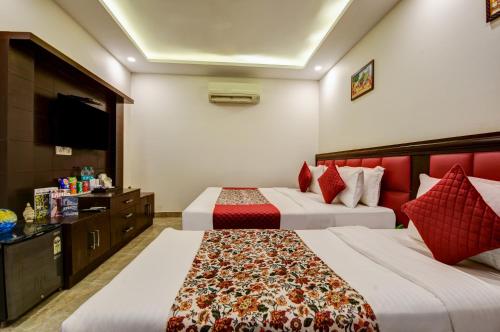 a hotel room with two beds and a television at Airport La Sapphire Hotel & Restaurant in New Delhi