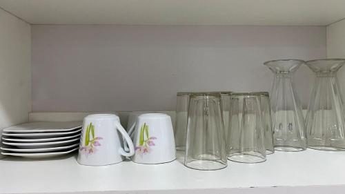 a white shelf with glass vases and plates on it at Departamento en barrio Petrolero in Sucre