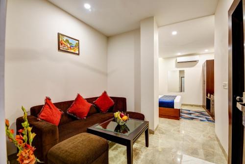a living room with a couch and a table at Airport La Sapphire Hotel & Restaurant in New Delhi