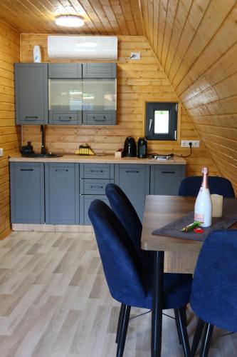 a kitchen with a table and blue chairs at PRIVATE PLACE Avrig adults only in Avrig