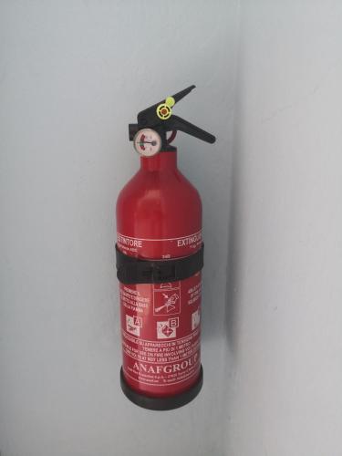 a red fire hydrant with a graduation hat on it at Short Lets Vacanze "Massimo" in Trappeto