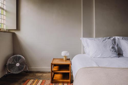 a bedroom with a bed and a night stand with a fan at Burgstraat 8 in Ghent