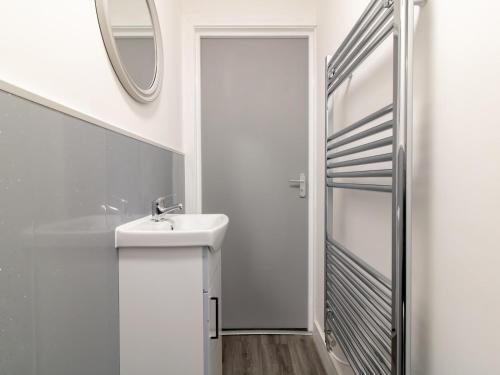 a white bathroom with a sink and a mirror at Spacious 4BR Home w Smart TVs Driveway Parking Pass the Keys in Darlington