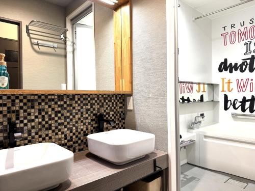 a bathroom with two sinks and a mirror at vacation rental SARAKU 茶楽来 in Osaka