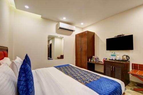 a hotel room with a bed and a tv at Airport La Sapphire Hotel & Restaurant in New Delhi