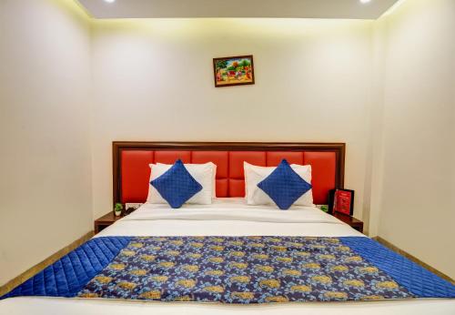 a bedroom with a large bed with a red headboard at Airport La Sapphire Hotel & Restaurant in New Delhi