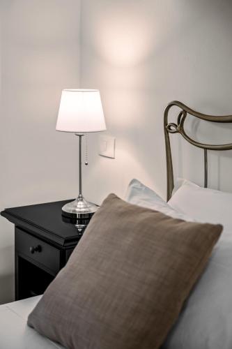 a bed with a pillow and a lamp on a table at Terra Dei Limoni in Noto Marina