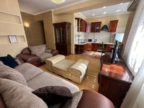a living room with a couch and a tv and a kitchen at Апартаменты на Назарбаева 44 in Karagandy