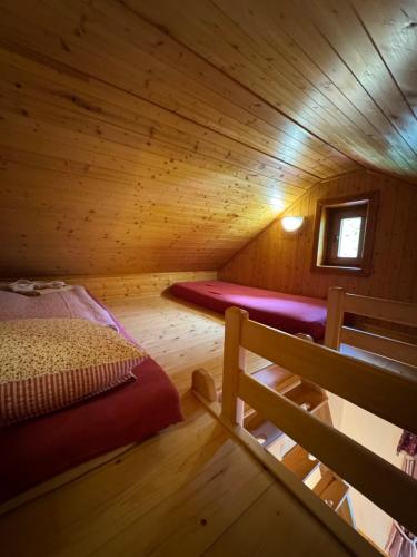 a room with a bed in a wooden cabin at bouda Pod Sněžkou in Pec pod Sněžkou