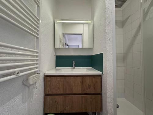 une salle de bain avec un lavabo et un miroir dans l'établissement L'Eclipse, à Fort-Mahon-Plage