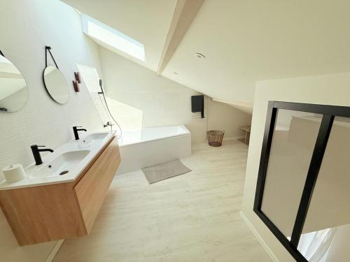 ein Badezimmer mit Waschbecken und Badewanne in der Unterkunft Villa NORMANDY in Saint-Georges-de-Didonne