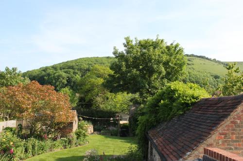 a view of a garden with a hill in the background at B&B South Downs Way in Poynings