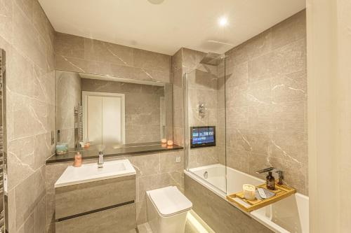 a bathroom with a toilet and a sink and a tub at 71 - Boutique Vibrant Apartment in Ramsgate