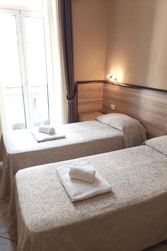 two beds in a hotel room with towels on them at Hotel Brianza in Milan