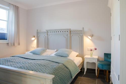 Un dormitorio con una cama y una silla azul. en Haus Sommerliebe, en Prerow