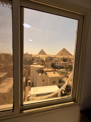 a window with a view of the pyramids from a city at Middle East pyramids veiw &jacuzzi in Cairo