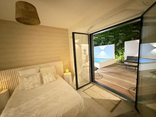 ein Schlafzimmer mit einem Bett und einer Glasschiebetür in der Unterkunft Villa NORMANDY in Saint-Georges-de-Didonne