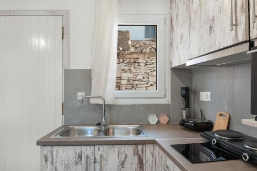 a kitchen with a sink and a window at Studio Fourni in Driopis in Dhriopís