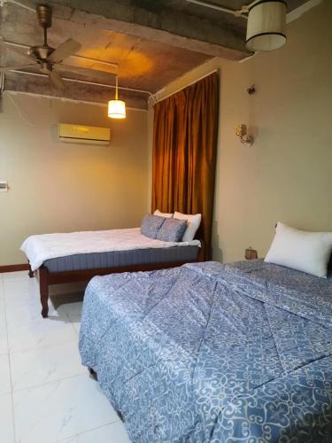 a bedroom with two beds and a window at Joes Homestay in Siem Reap
