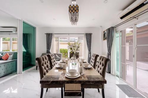 a dining room with a long table and chairs at Kevin's Pool Villa at Chiang Mai - 4BDR 4Bath Airport & Old City 5min in Chiang Mai