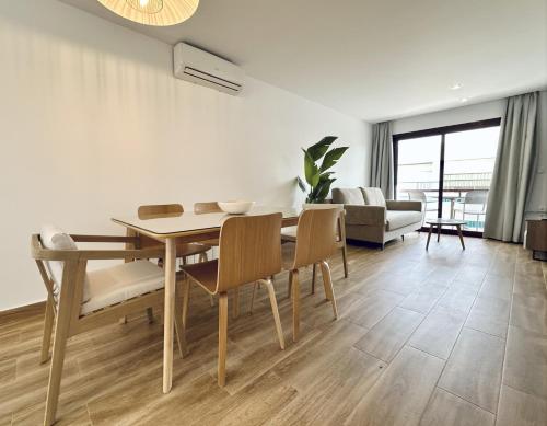 a dining room with a table and chairs and a couch at Apartamentos Turísticos Santo Rostro in Chipiona