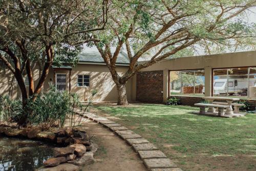 a house with a picnic table and a pond at Kwetu Guest Farm in Swellendam