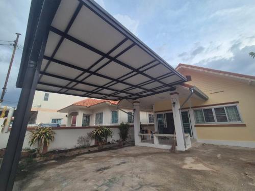 a pergola over the front porch of a house at 94 Yellow house in Khon Kaen