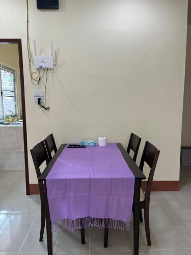 a table with a purple table cloth on it at 94 Yellow house in Khon Kaen
