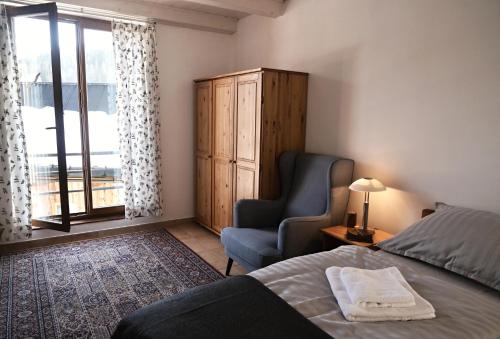 una camera da letto con un letto, una sedia e una finestra di Hotel Modřín a Pec pod Sněžkou