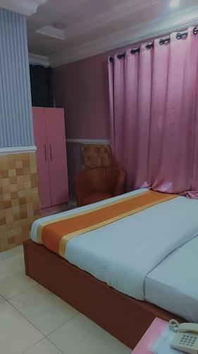 Una cama o camas en una habitación de Camzy Villa Hotel
